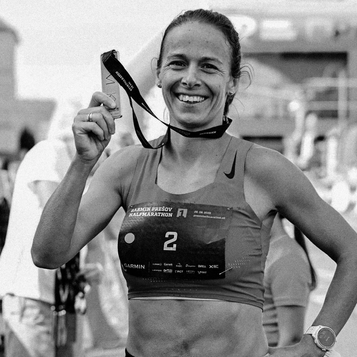 Female runner with her medal after completing the Garmin Prešov Halfmarathon 2026.
